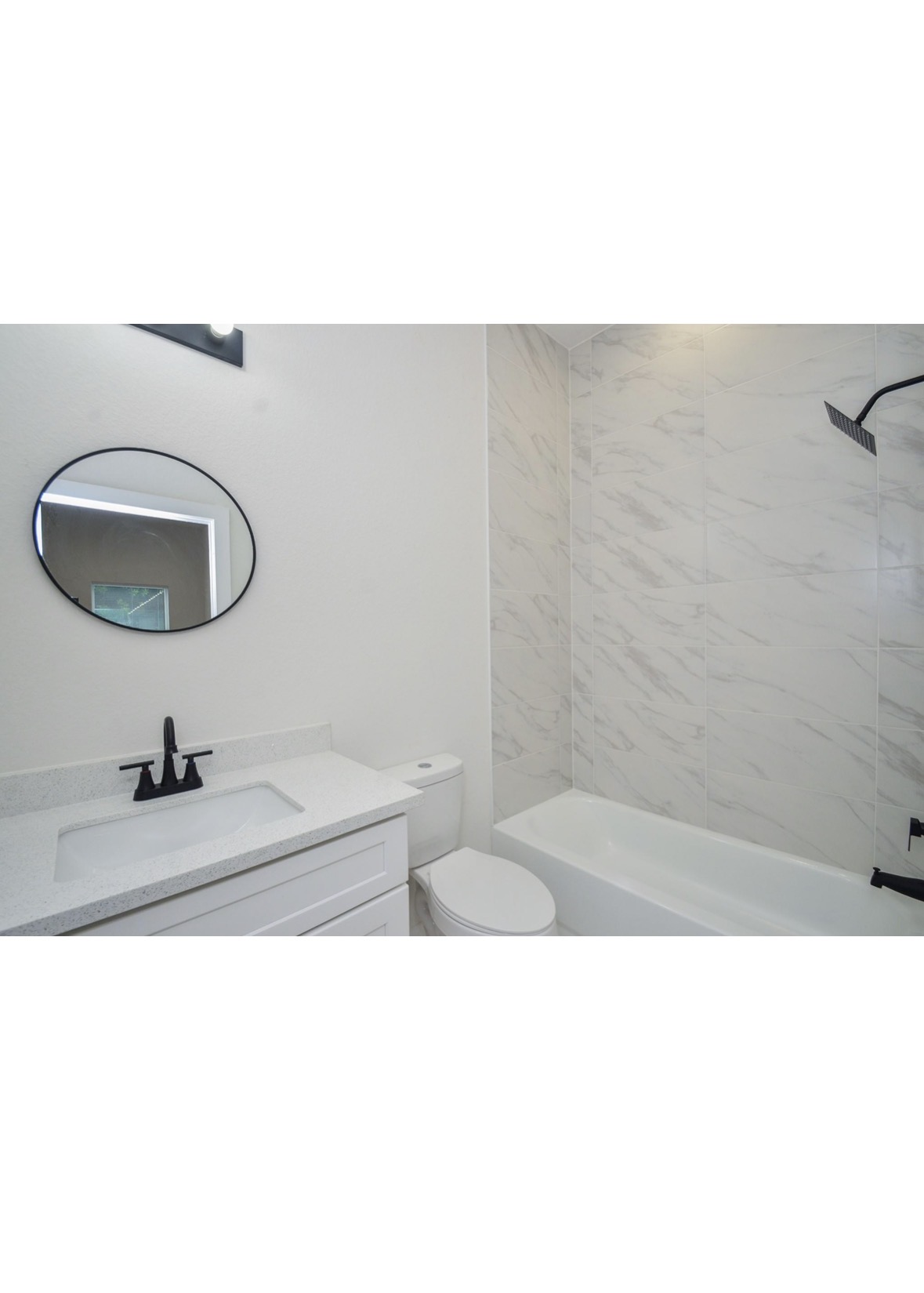 Clearwater bathroom with round mirror and tub