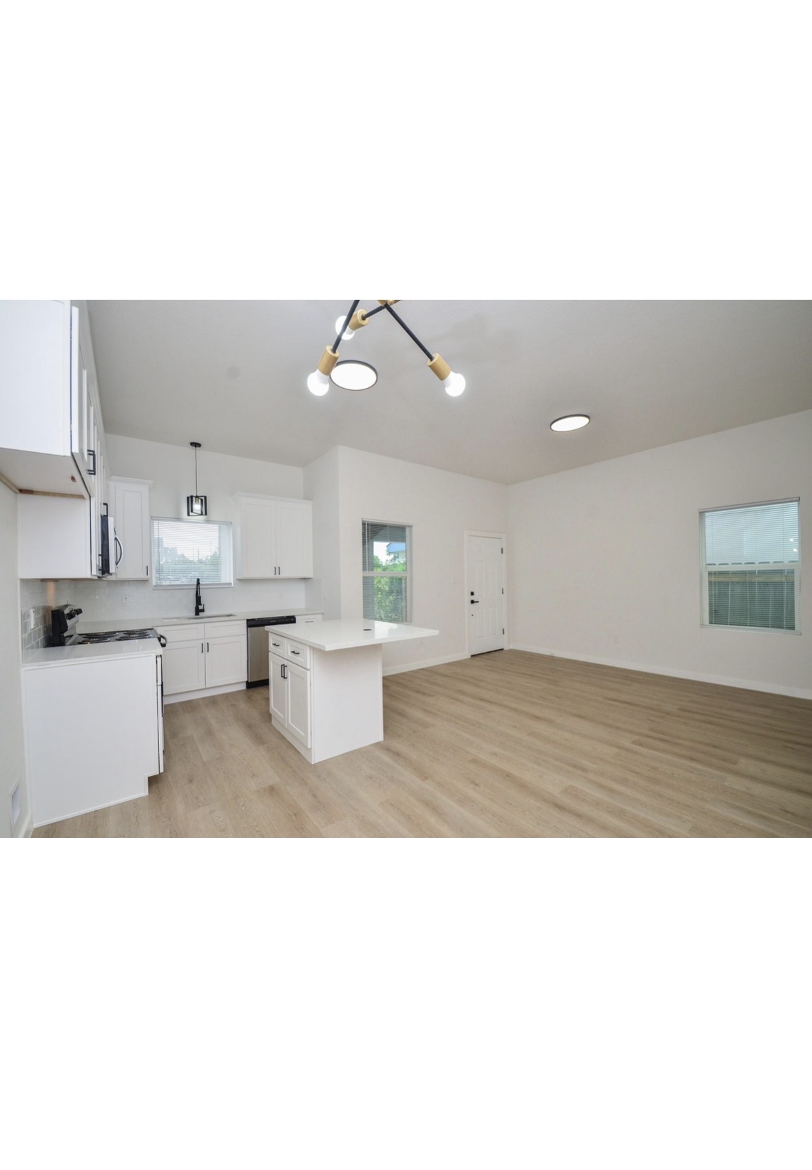 Clearwater kitchen and open living space with white cabinetry and wood-look floors